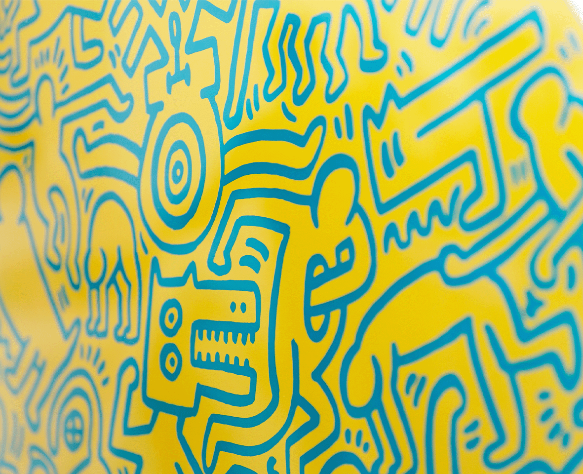Detailaufnahme des Kunstwerks 'Pyramid' von Keith Haring – Detail von blauen Linienfiguren auf Gelb.