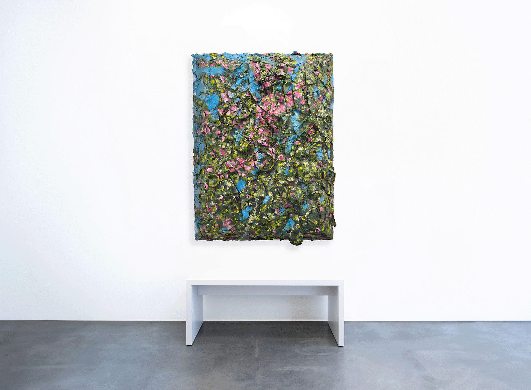 Das lebendige Gemälde „Julian Schnabel – Ohne Titel“ von Geuer & Geuer, voller strukturierter Grün-, Rosa- und Blautöne wie Porzellan auf Aluminium, ziert eine weiße Wand über einer einfachen weißen Bank auf einem grauen Betonboden.